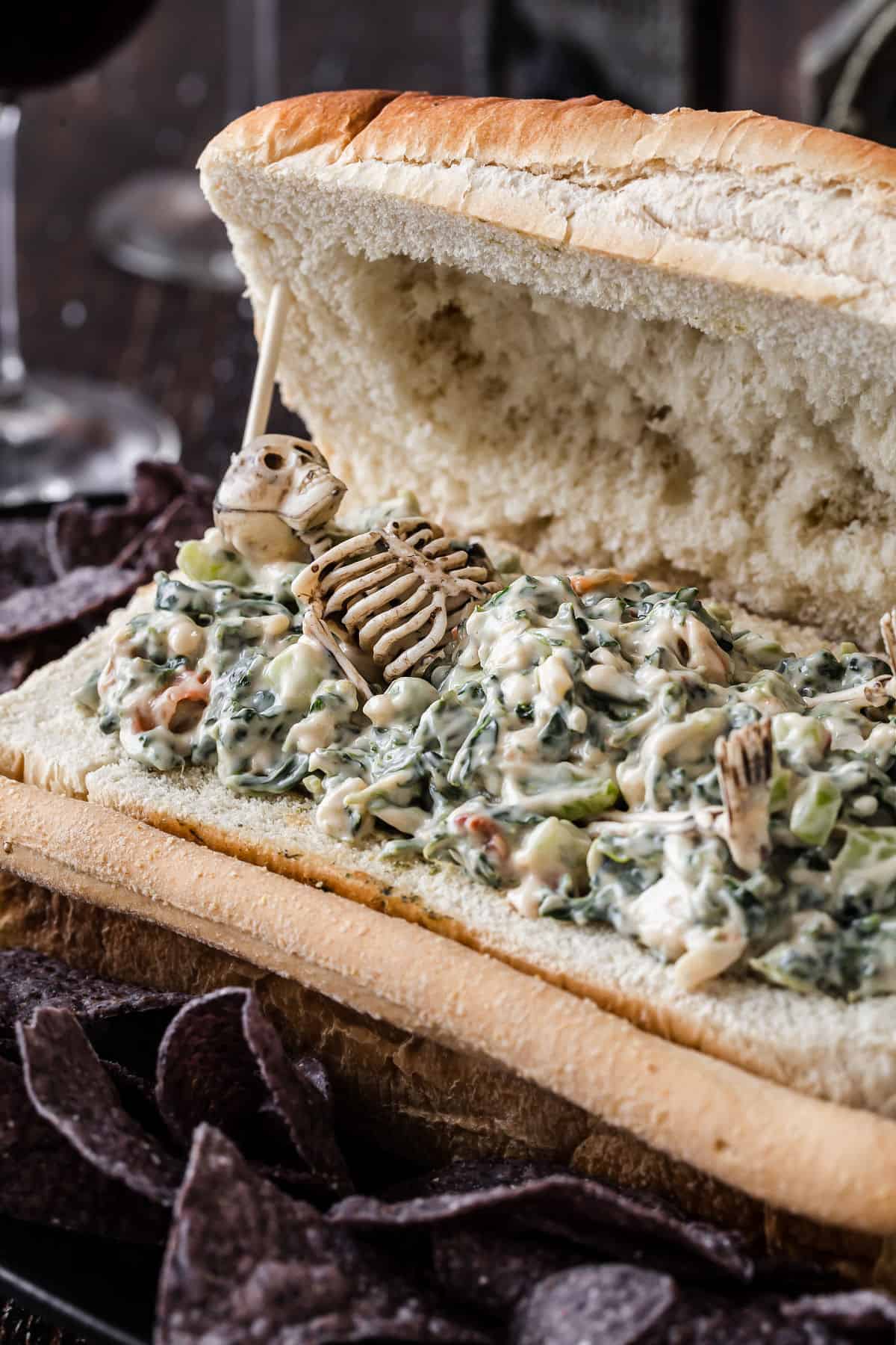 mini skeleton in spinach dip in bread coffin