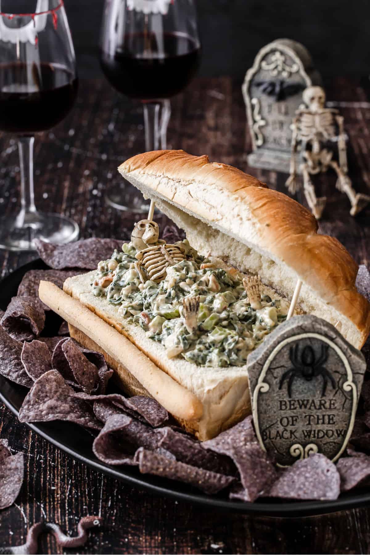 halloween appetizer bread with spinach dip and mini skeleton inside