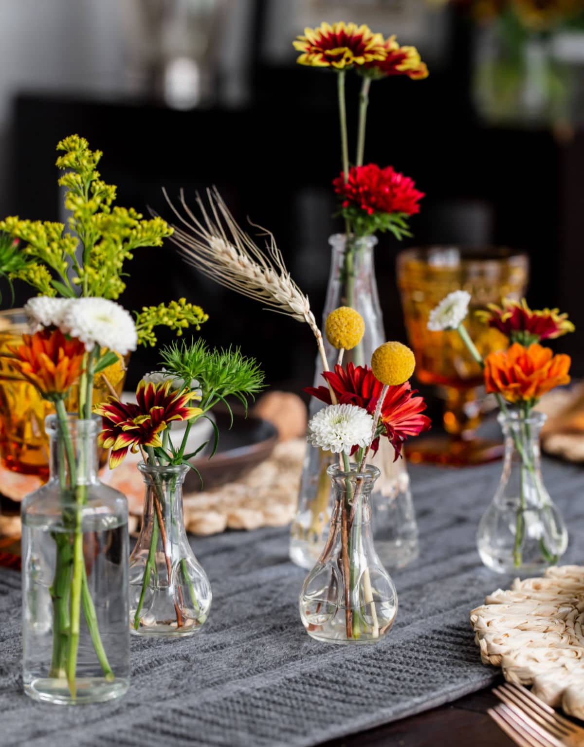 bud vases with fall flowers on dinner table