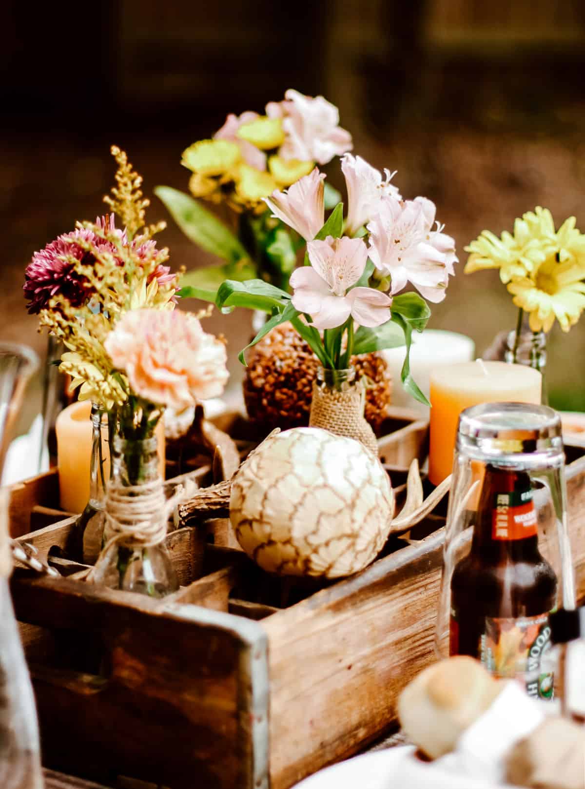 vintage bottle crate with bottles filled with flowers as a centerpiece