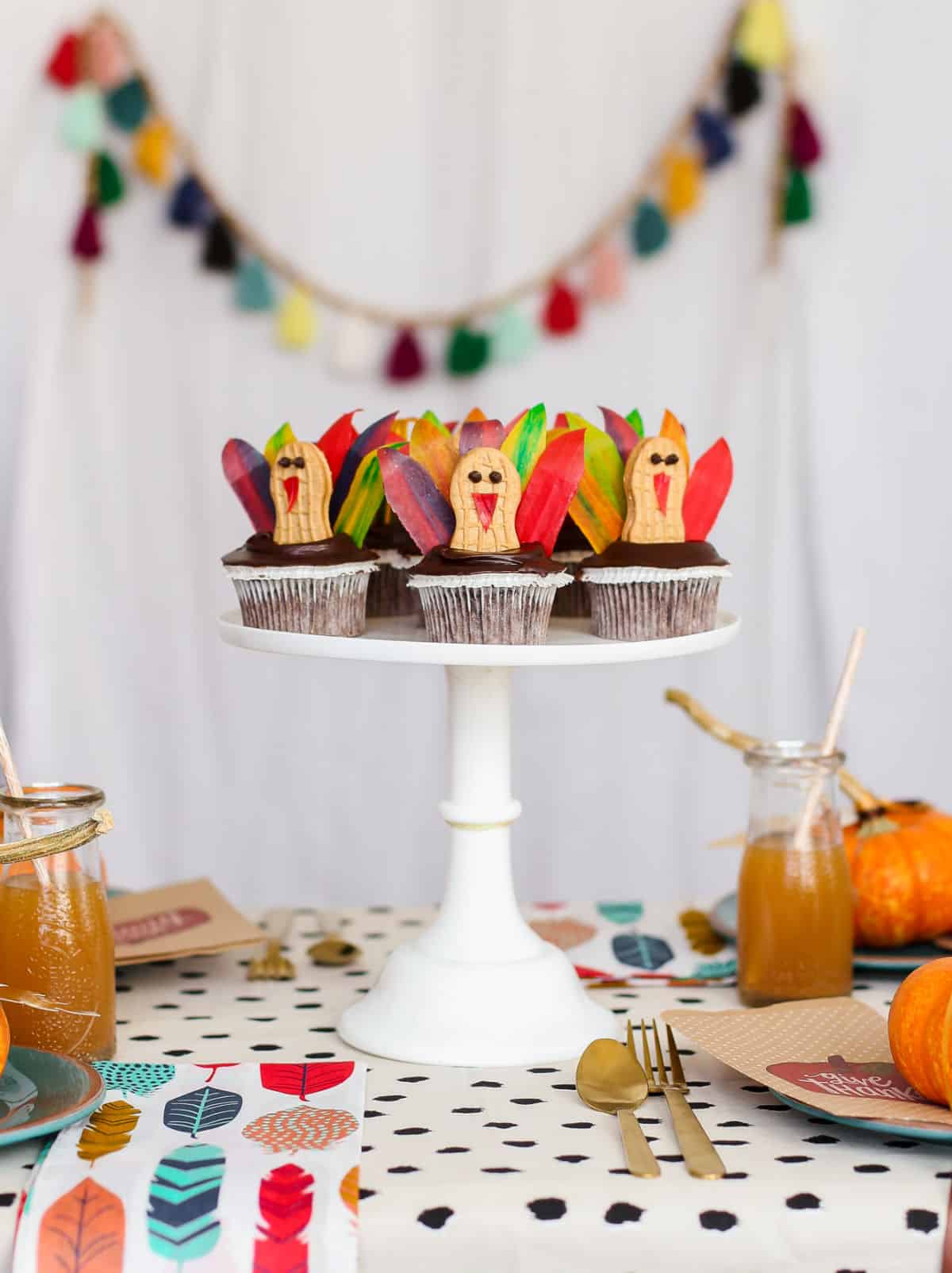 turkey cupcakes on white pedestal in center of kids dinner table