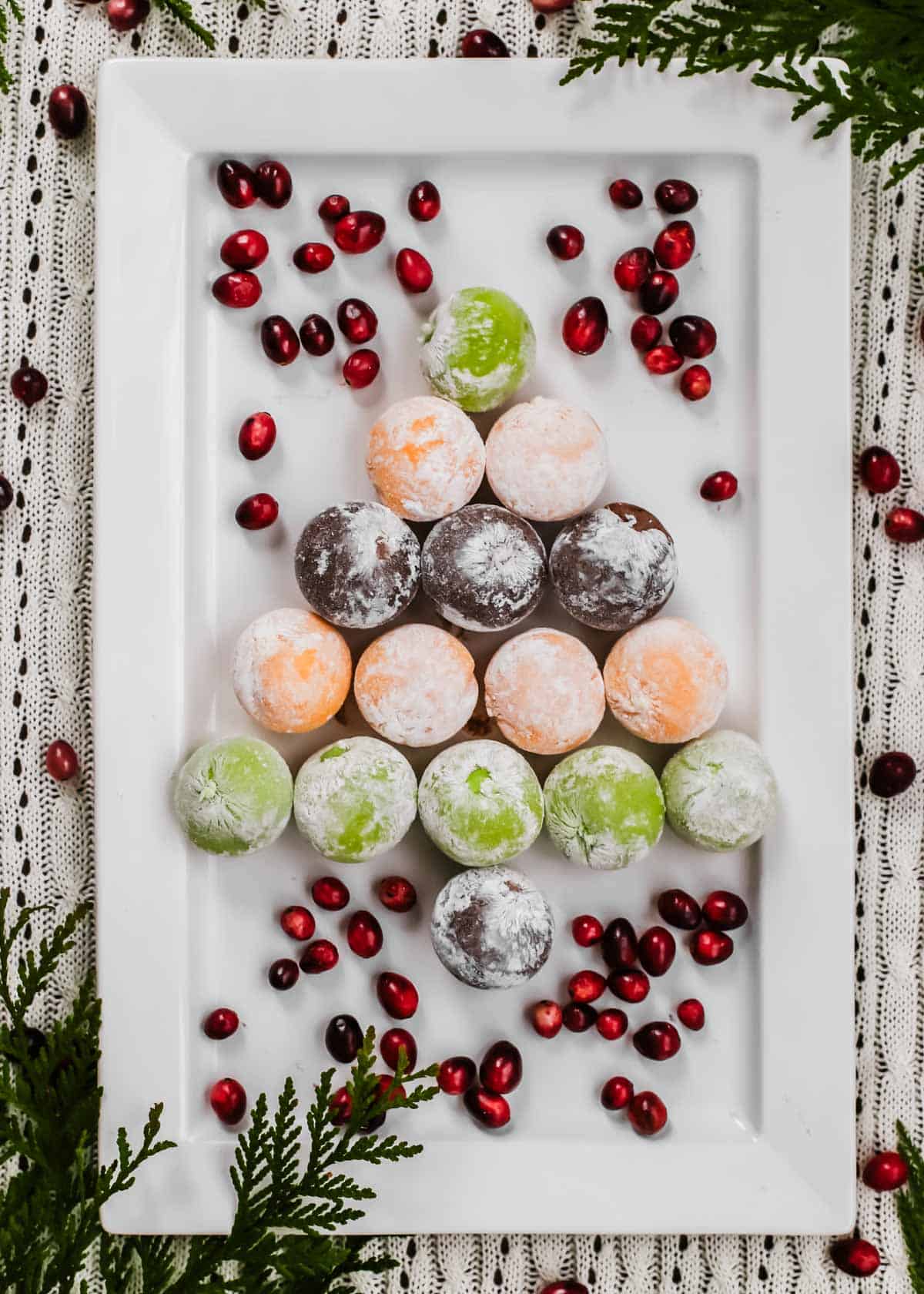 mochi balls on white platter in the shape of a Christmas tree.