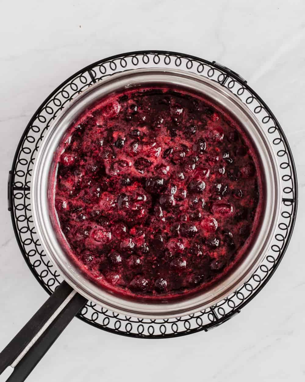 fresh cranberries cooked down to a sauce in saucepan.