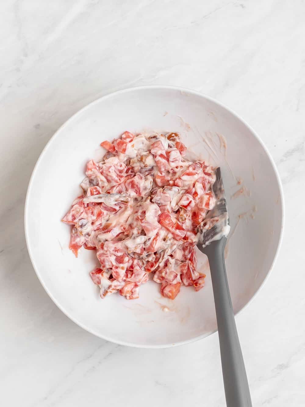 mixture of tomatoes, bacon, mayonnaise in white bowl.