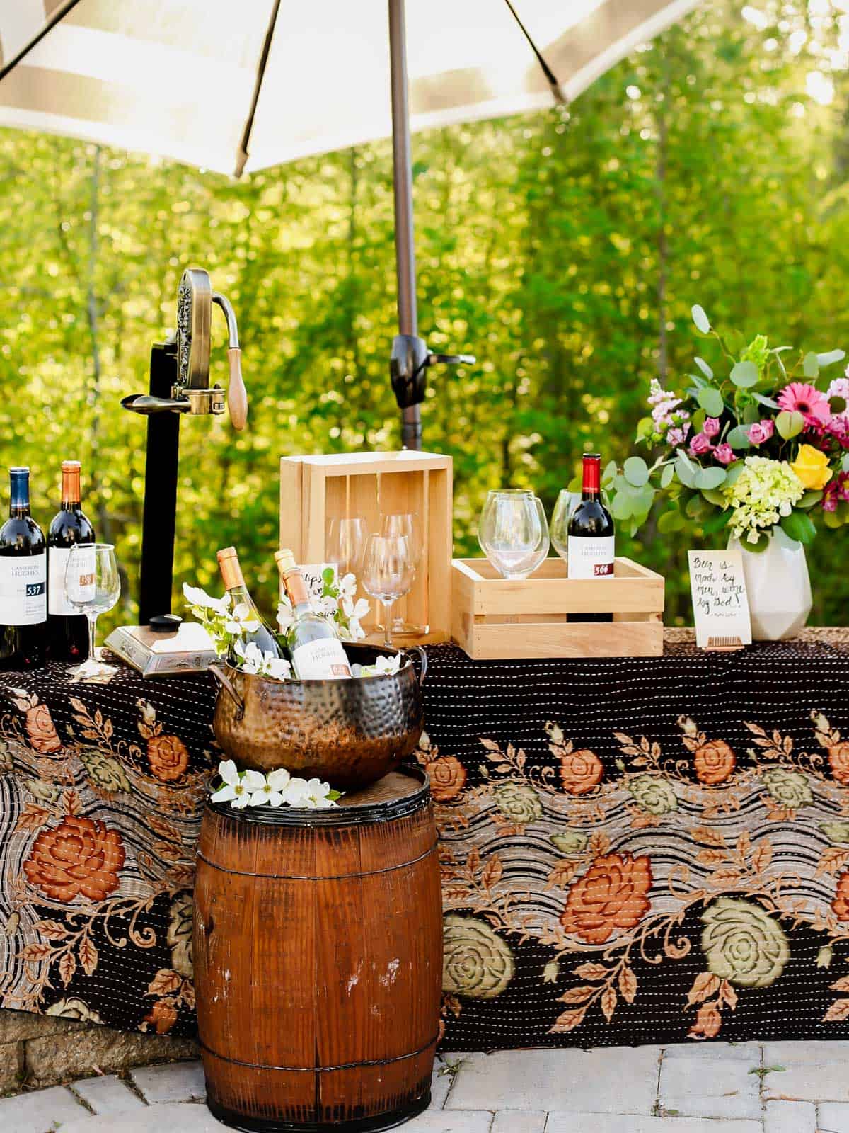 a display of wine set up outside, using rustic wood crates and wine barrel.