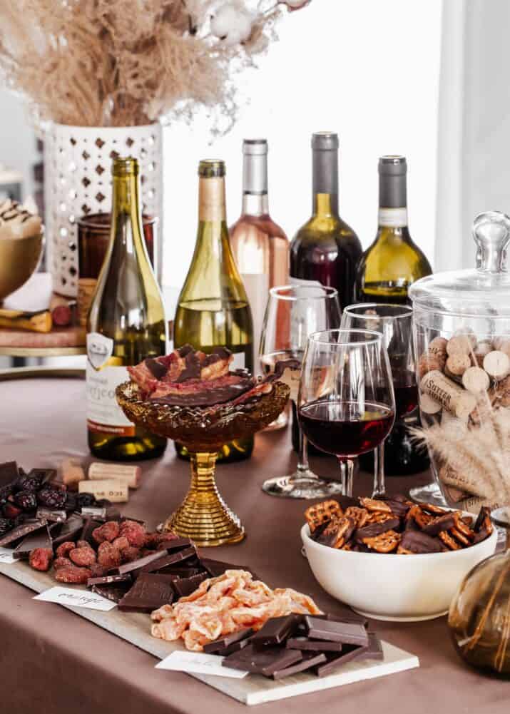 party table set up with bottles of wine and lots of chocolate and dried fruit for tasting.