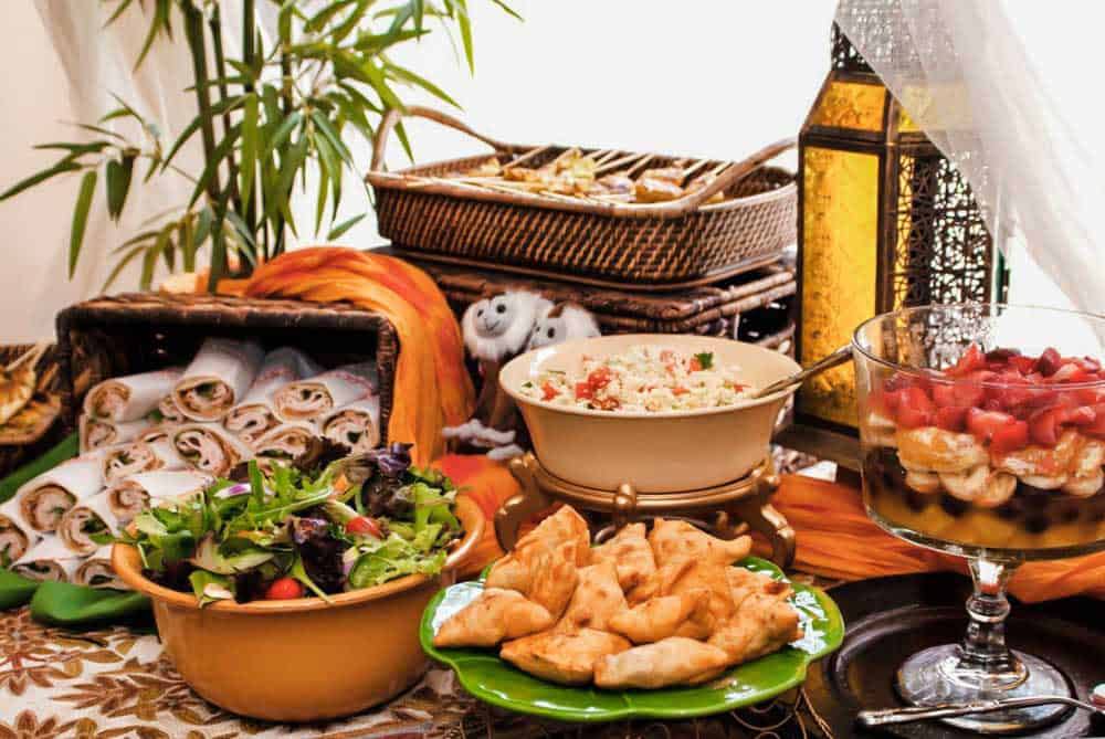 International style food buffet with baskets of food and rug table cover.