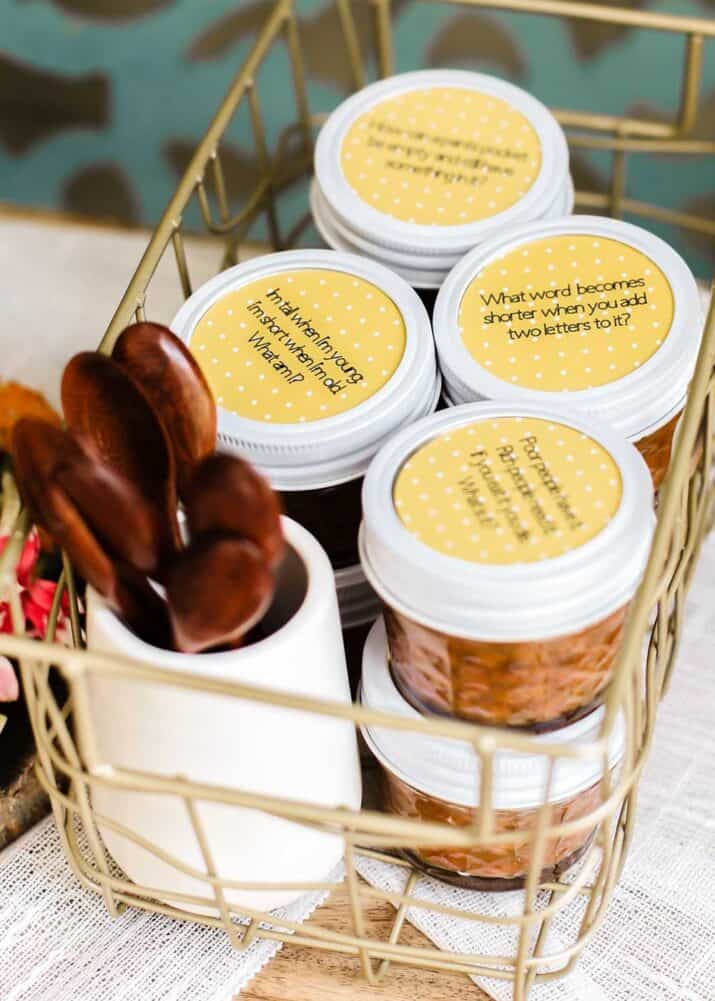 wire basket on table, holding small jars of baked beans.