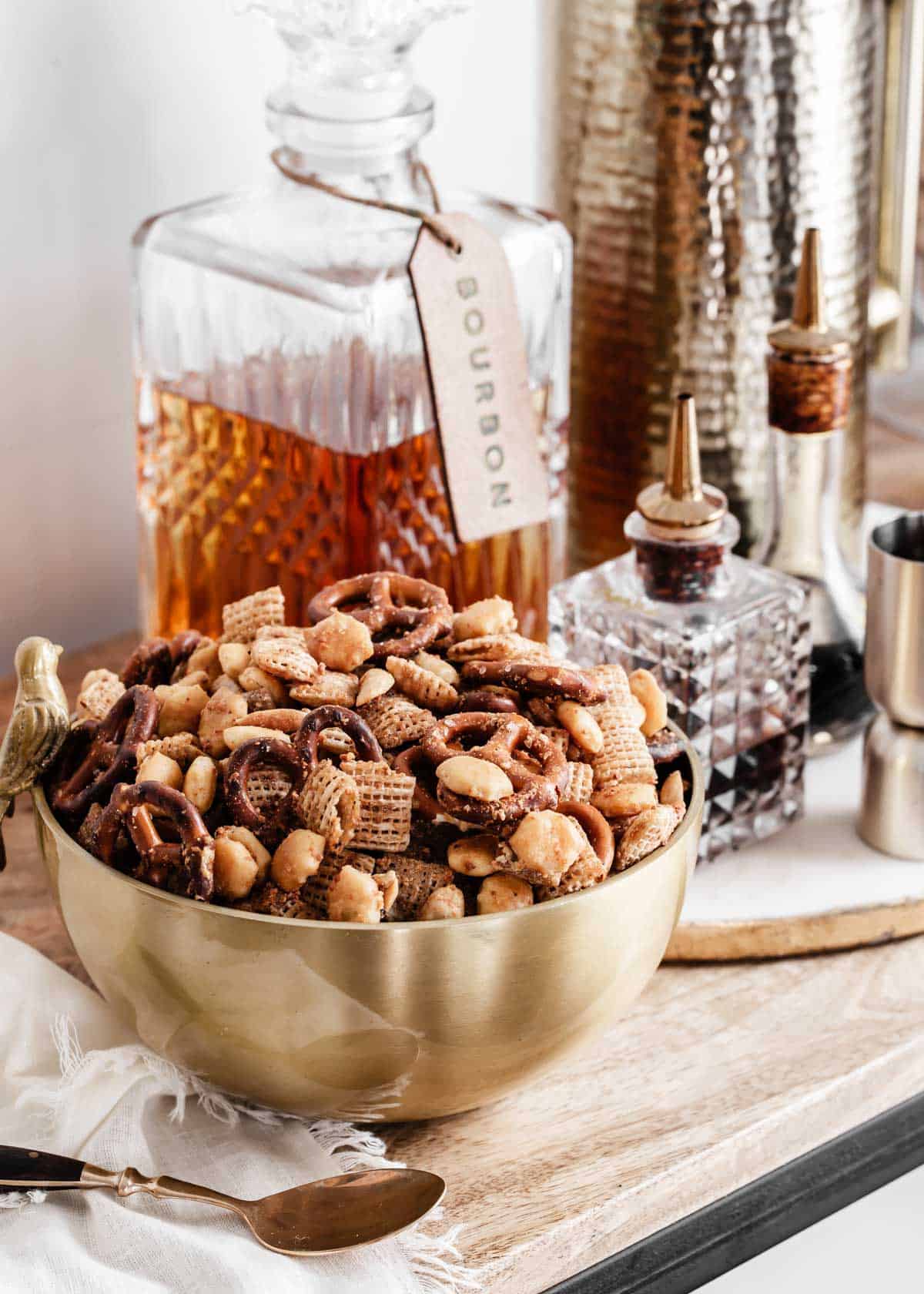 gold bowl of Chex Mix on a home bar.