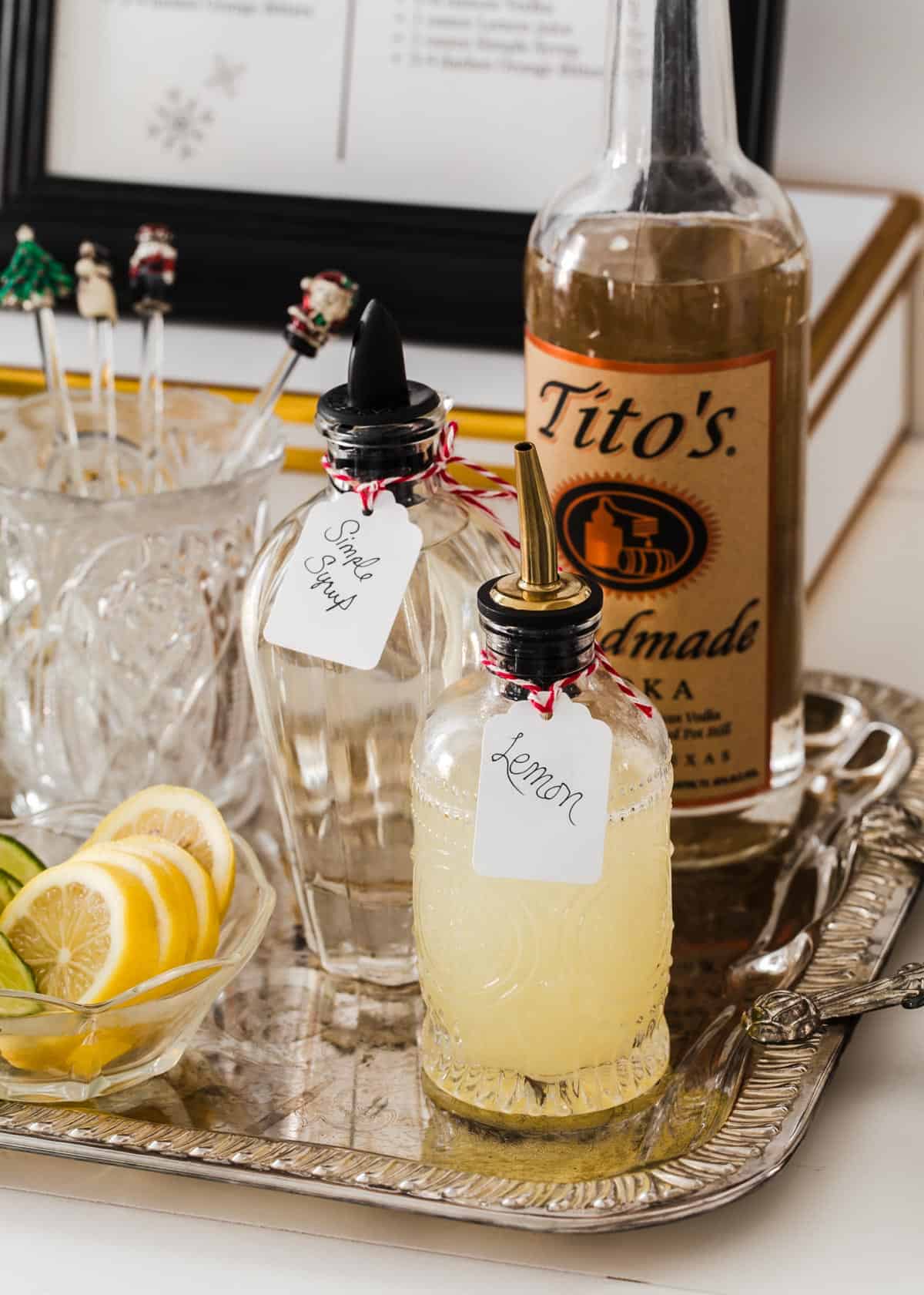 silver tray with vodka, and small decanters of lemon juice and simple syrup.