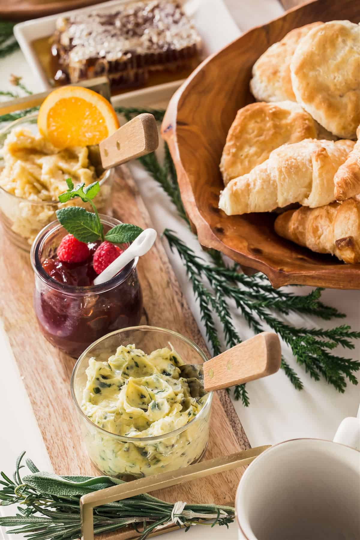 compound butter and jam on table with croissants and biscuits