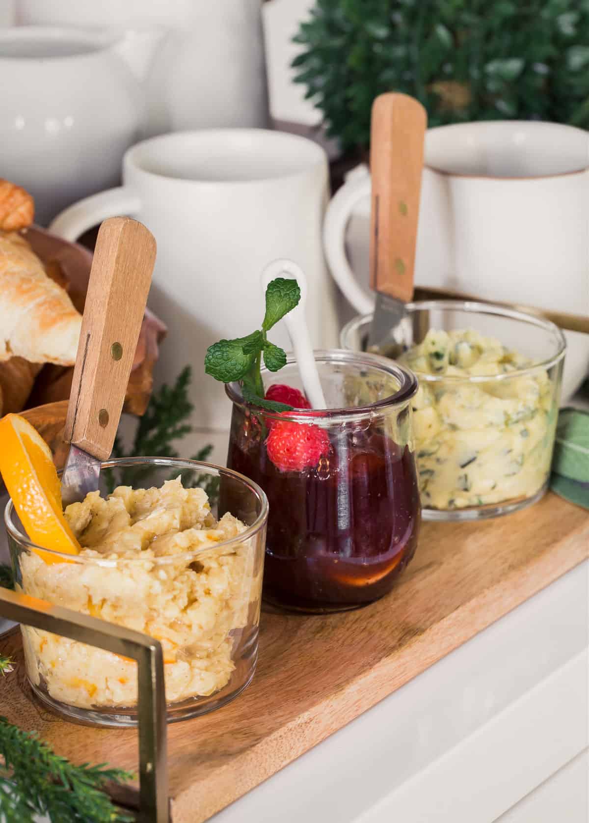 small wood tray holding 3 jars of butter and jam.