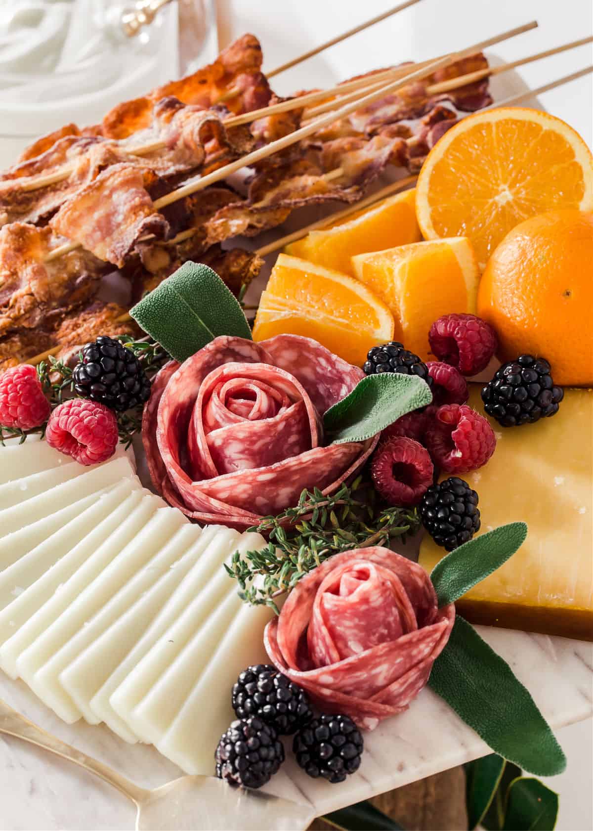 salami roses and cheeses with bacon and oranges