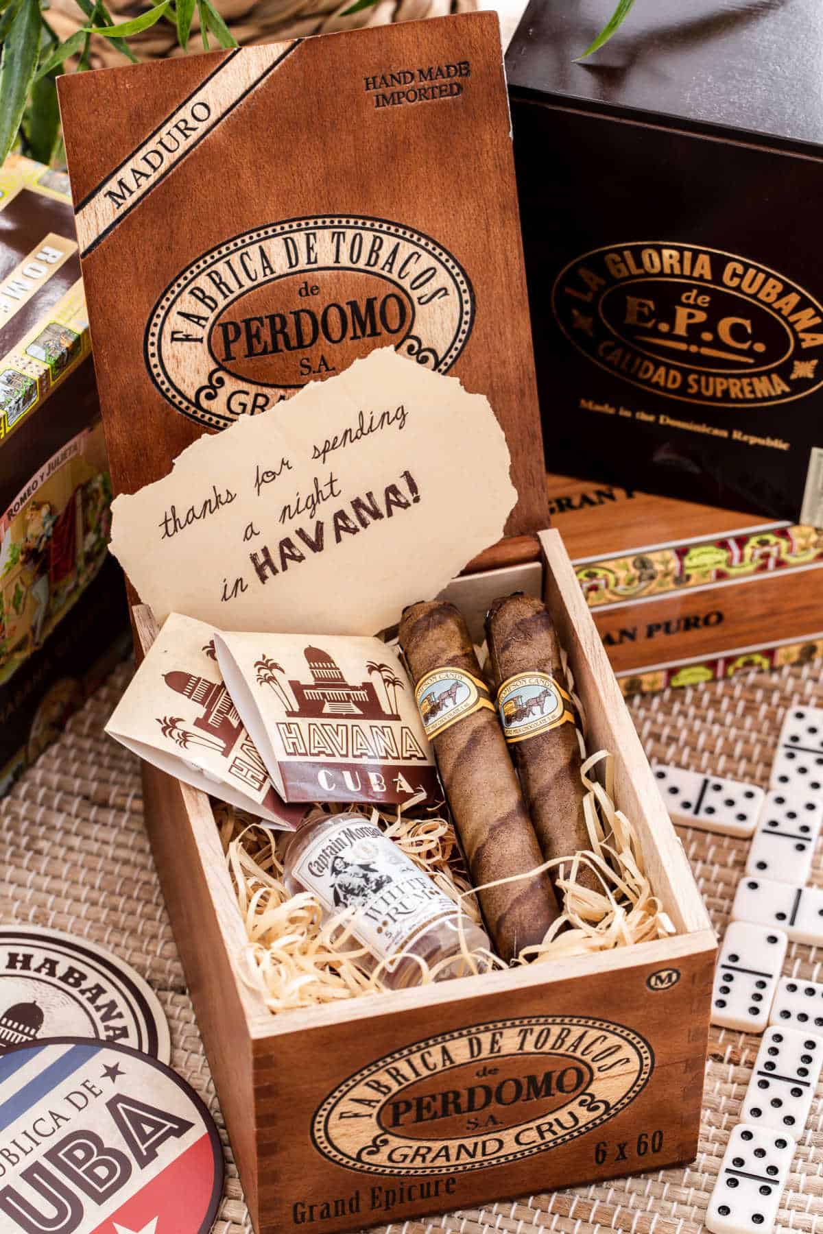 cigar box filled with candy cigars, matches, and mini rum bottle.