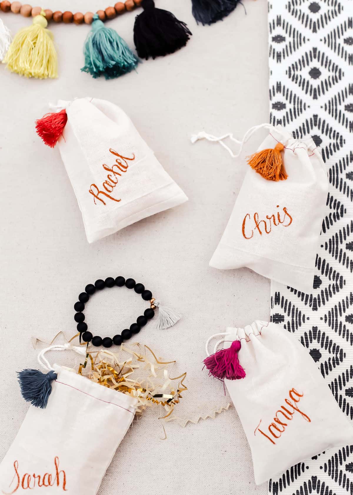 party favor muslin drawstring bags with names written on each and tassel detail.