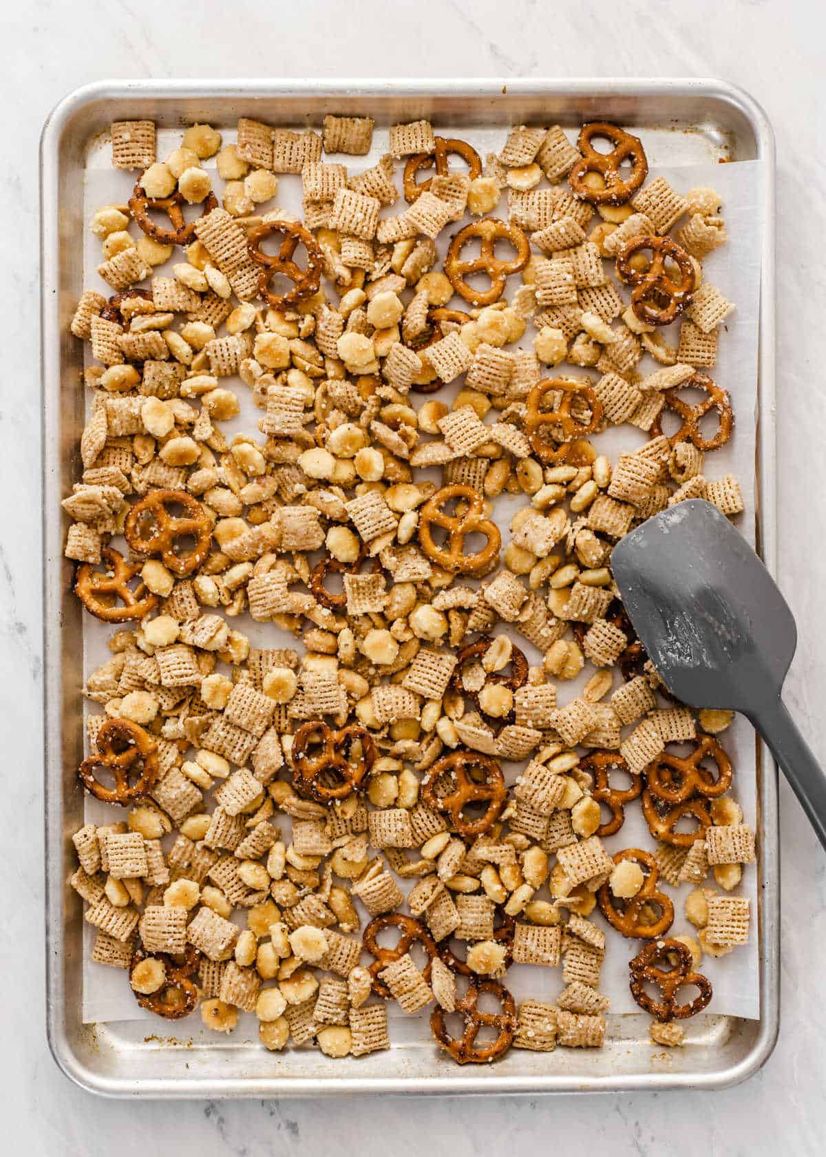 baking sheet with Chex snack mix prepared and ready to bake.
