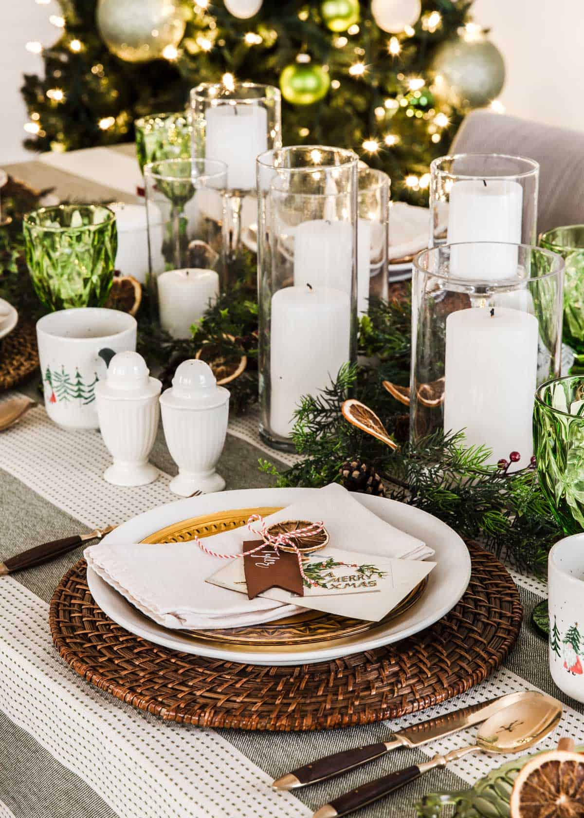 green and white Christmas tablescape with lots of white candles for centerpiece.