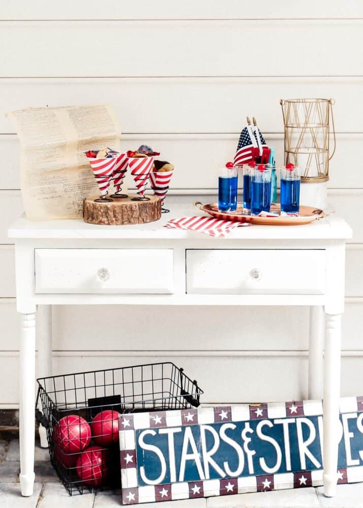 console table set up outside with 4th of July decoration and drinks.