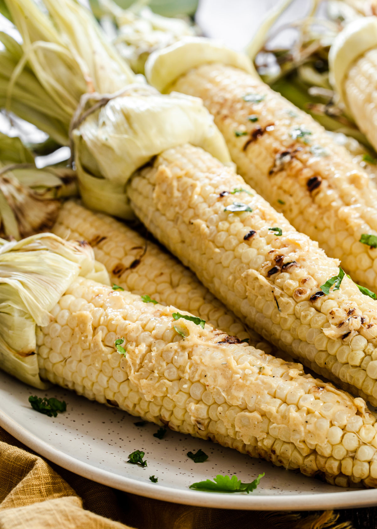 grilled corn with husks pulled back, smothered in butter.