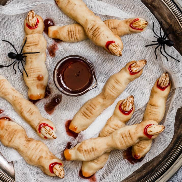 cookies look like witch fingers on white gauze with Halloween props, spiders