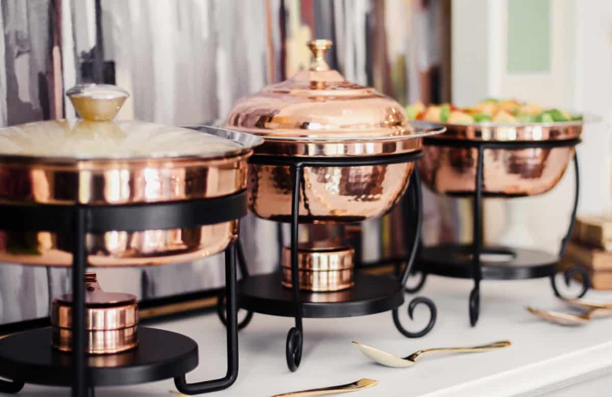 three copper chafing dishes on white table.