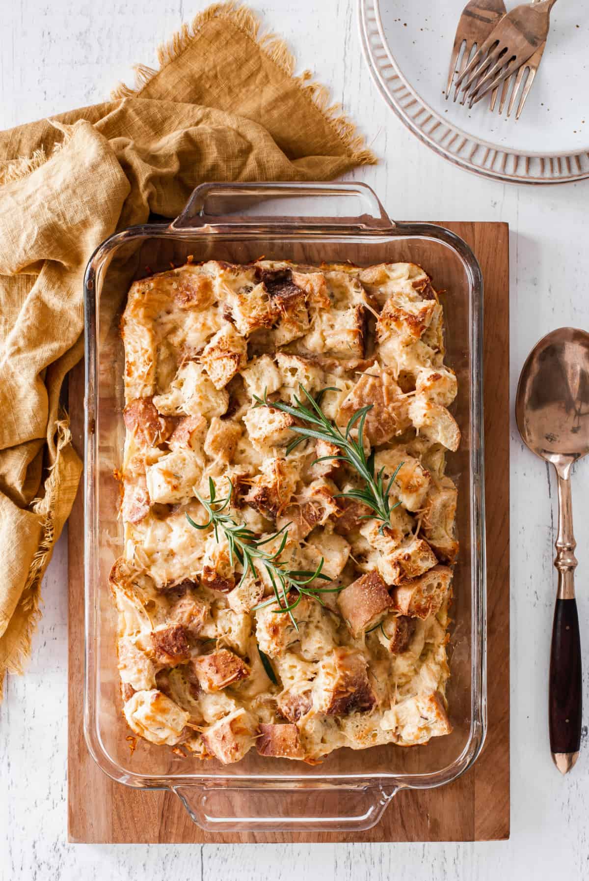 rosemary parmesan bread pudding in glass casserole dish, overhead view