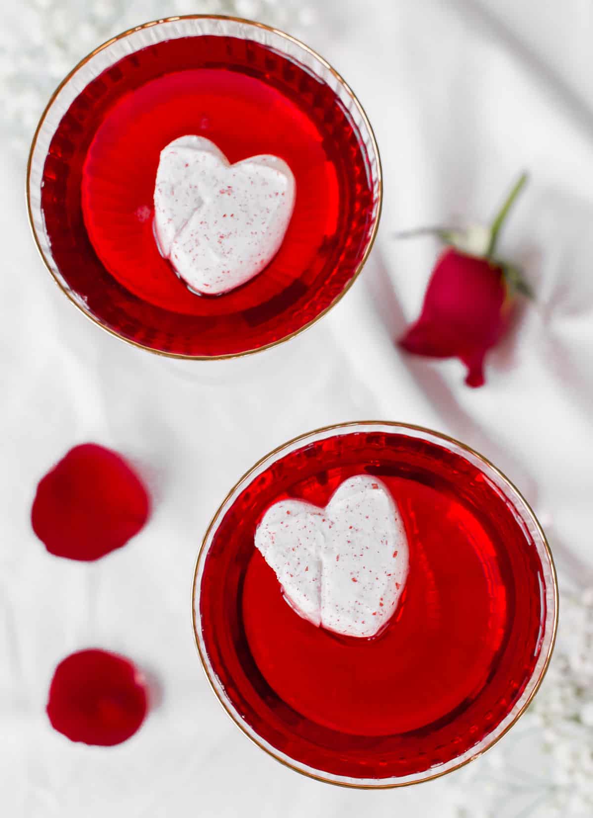 overhead view of red drinks with heart shaped marshmallows on top.