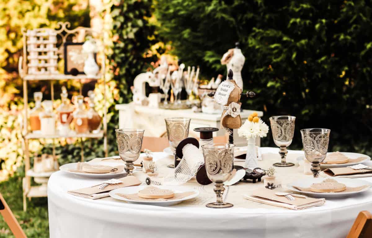 outdoor tablescape with shabby chic decorations and other party tables in background.