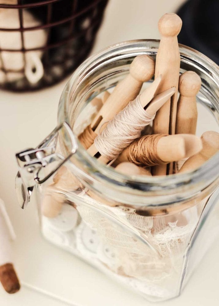 small jar filled with thread-wrapped vintage clothespins. 