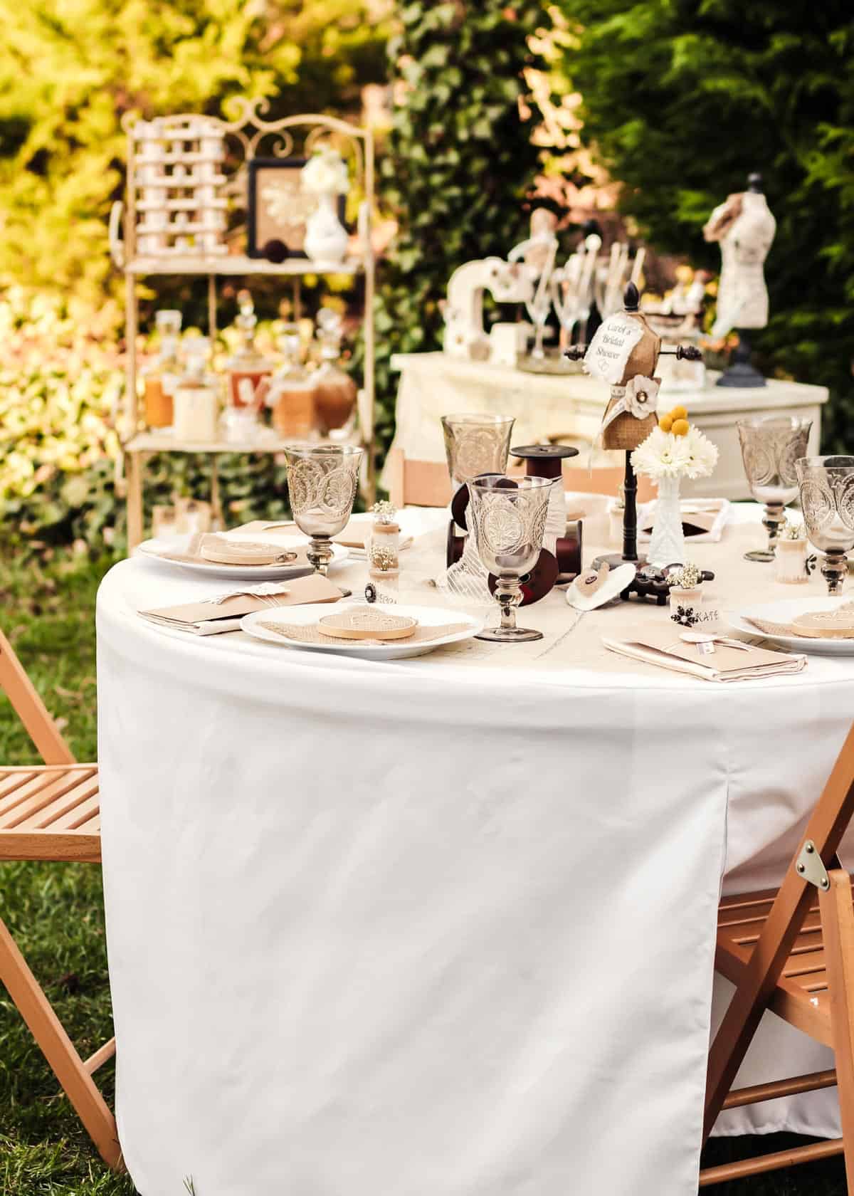 outdoor tablescape with shabby chic decorations and other party tables in background.