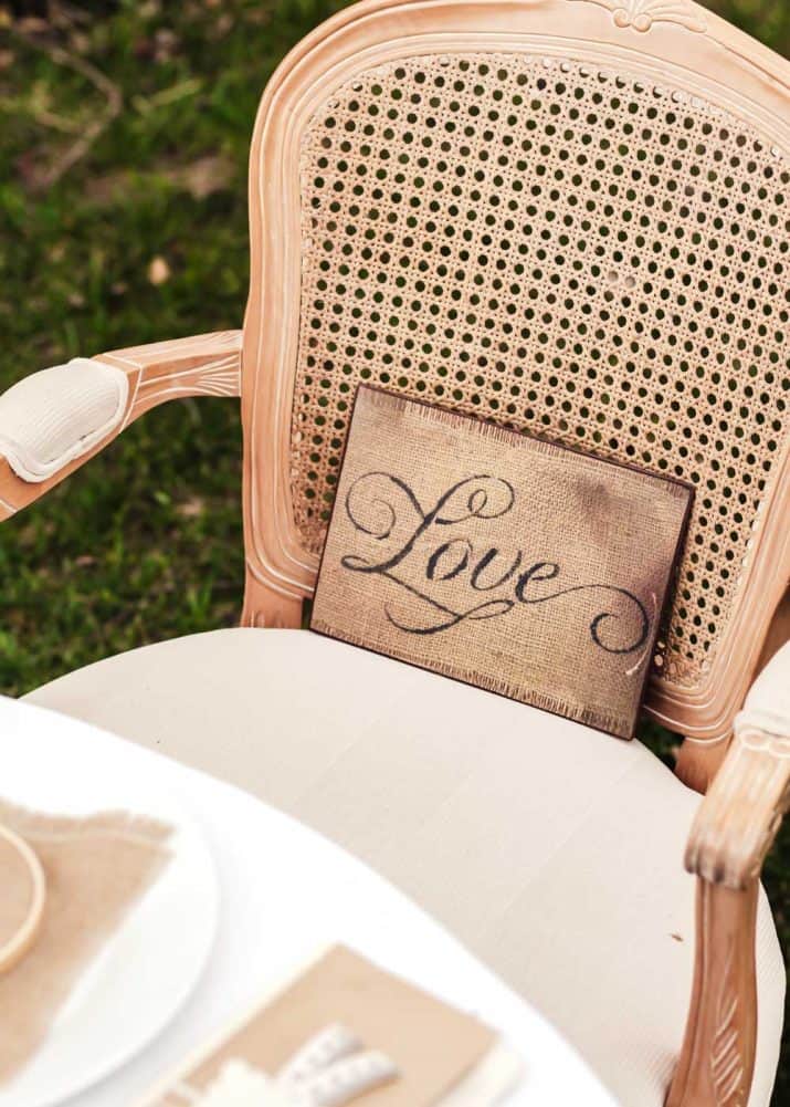 Louis style chair with LOVE sign in the seat leaning against the back.