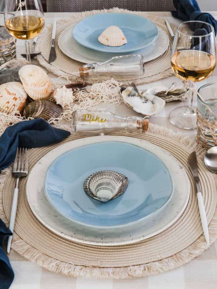 nautical dinner party place setting with shells, and blue and tan colors.