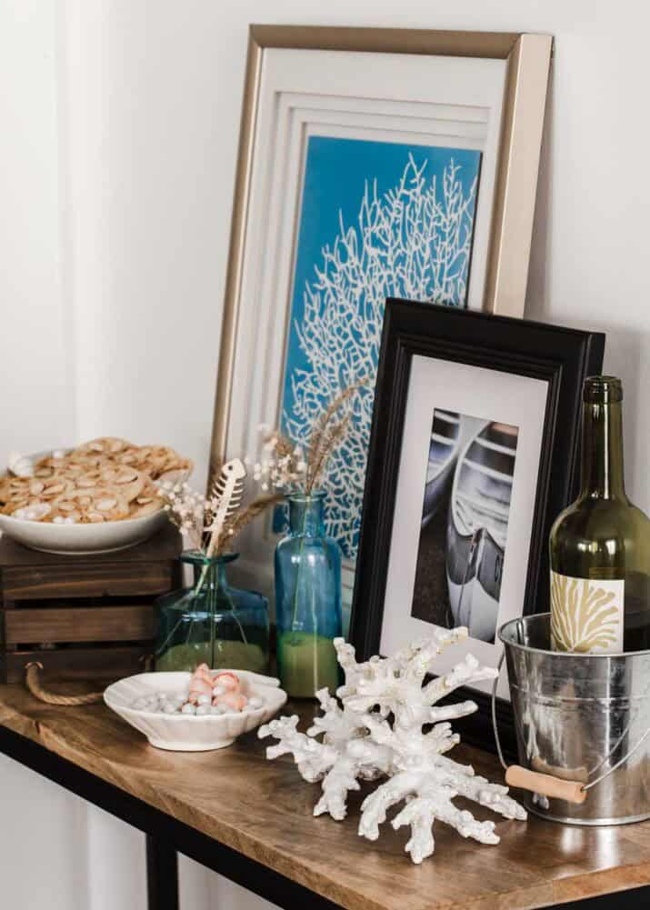 small buffet table with dessert and nautical decorations and artwork.