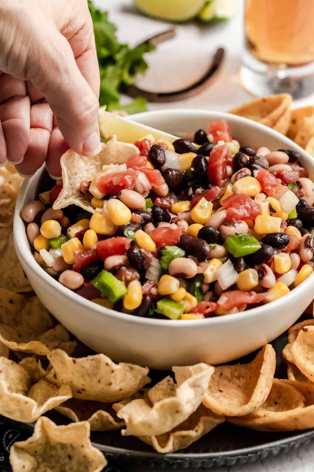 hand scooping cowboy caviar with a tortilla scoops chip.