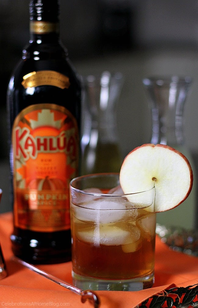 apple pumpkin spice cocktail in highball glass with apple slice and Kahlua bottle