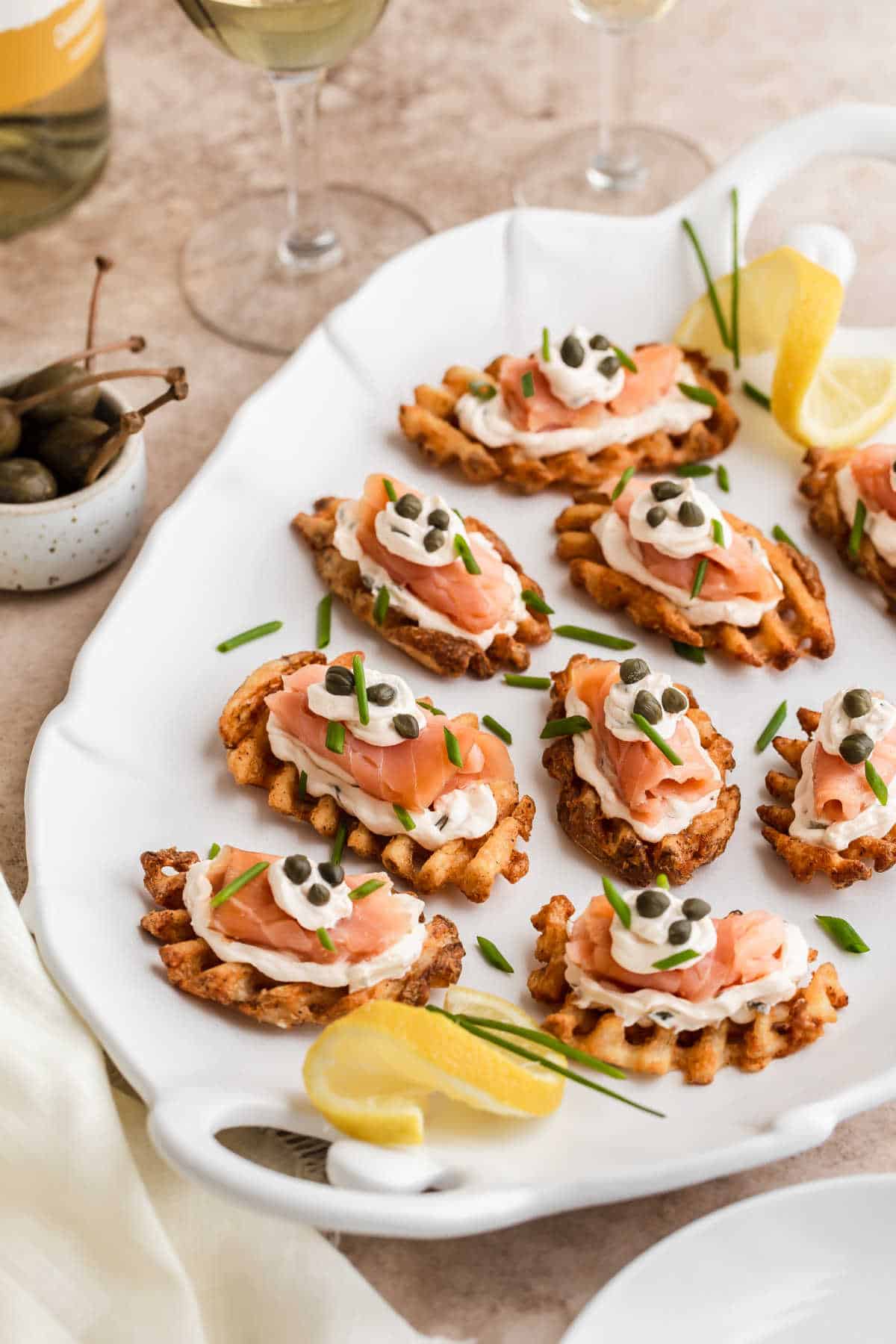 white platter with lots of salmon potato appetizers on it.