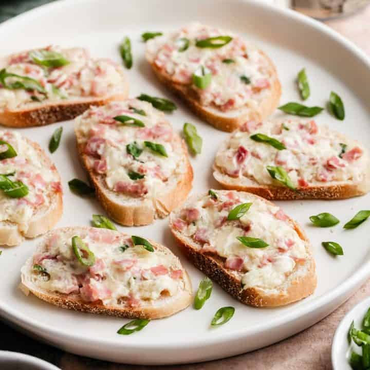 ham and cheese mixture on crostini, garnished with green onion slices.
