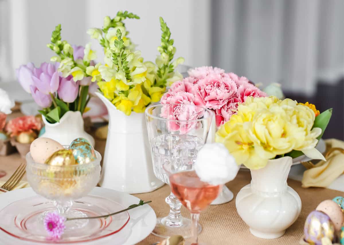 Easter tablescape with mini vases filled with different colors of spring flowers.