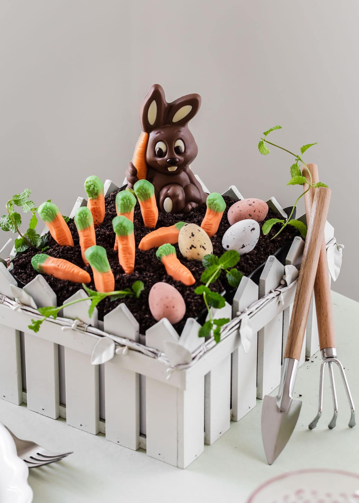small wood tray shaped like a fence with Easter garden dirt cake inside.