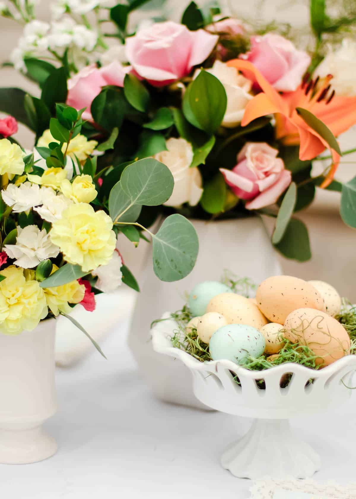 flower arrangements with dish of Easter eggs.