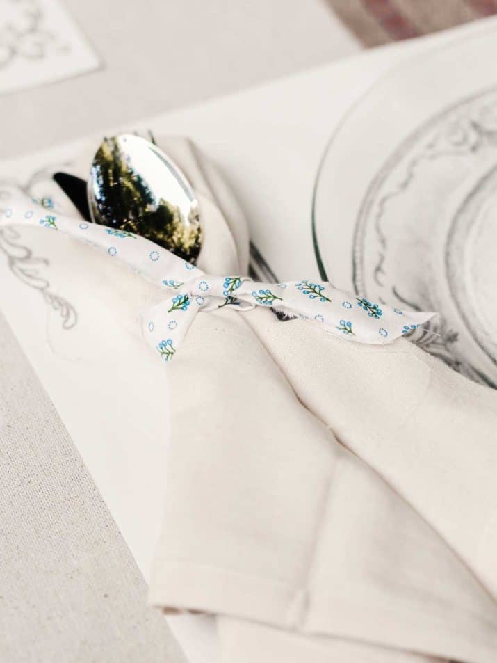 silverware wrapped in cream napkin, tied with vintage fabric ribbon.