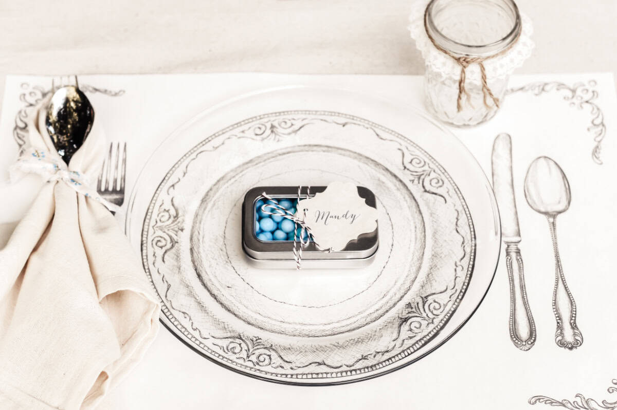 vintage style placemat with clear glass plate and tin candy holder on top.