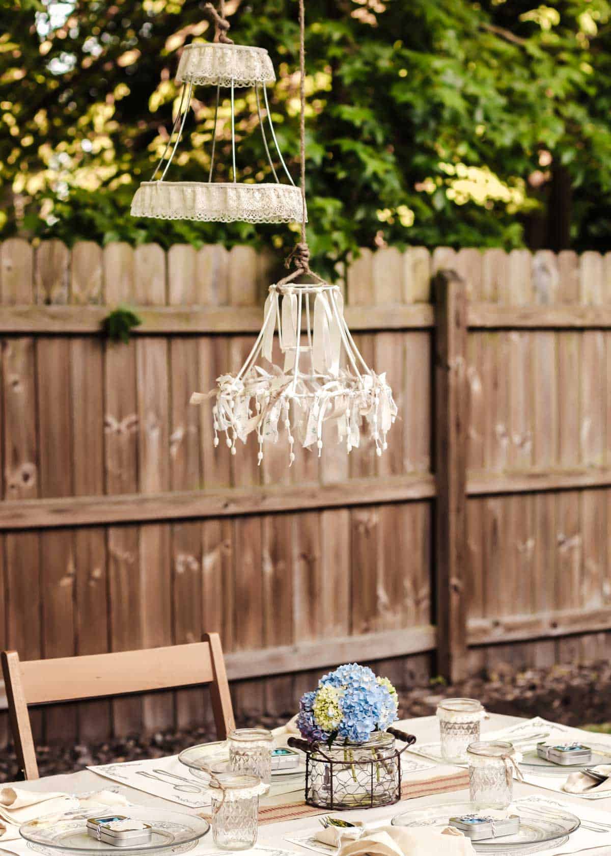 table setting outside with hanging lamp shades above.