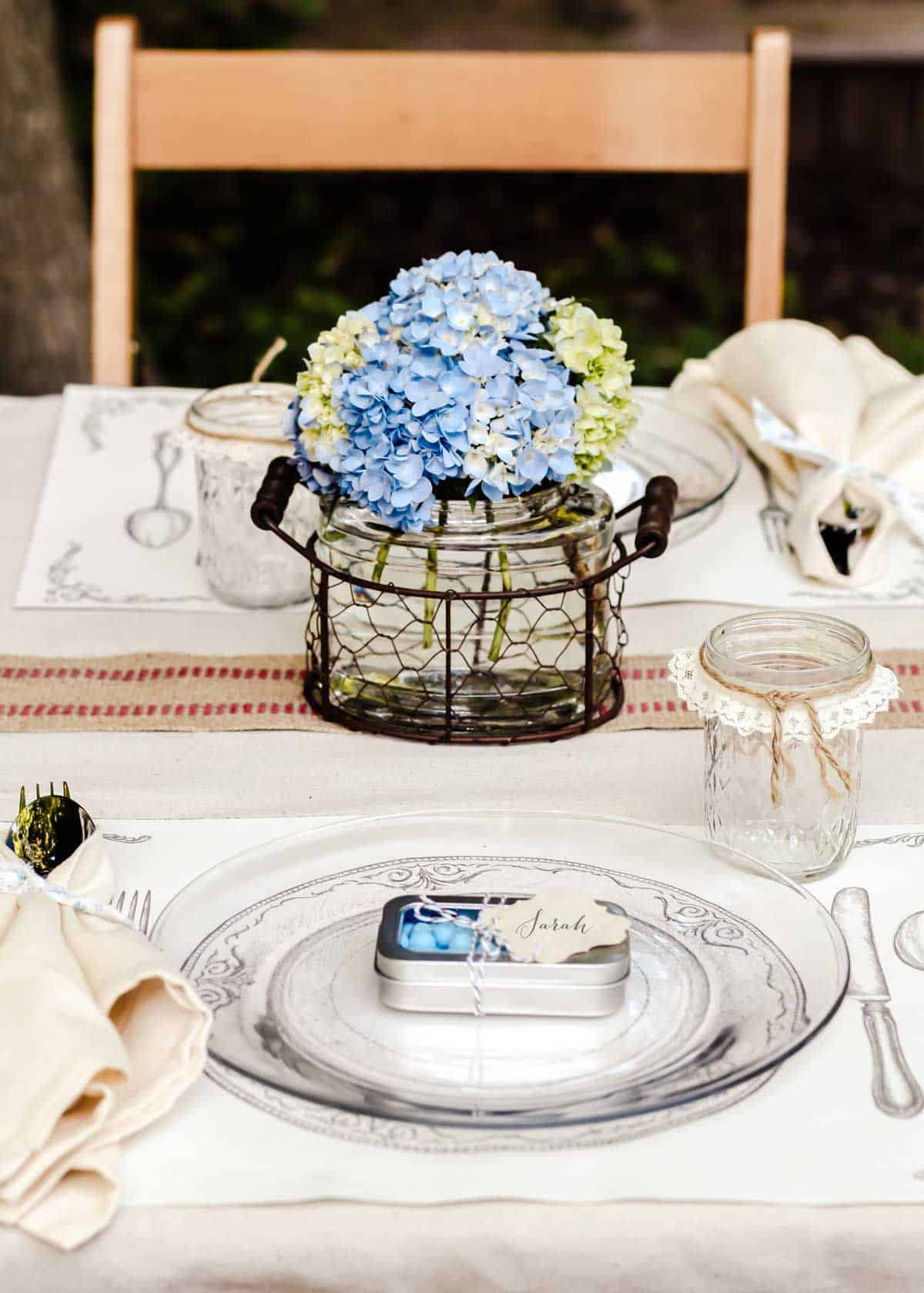 luncheon table set up outside, with hydrangea centerpiece.