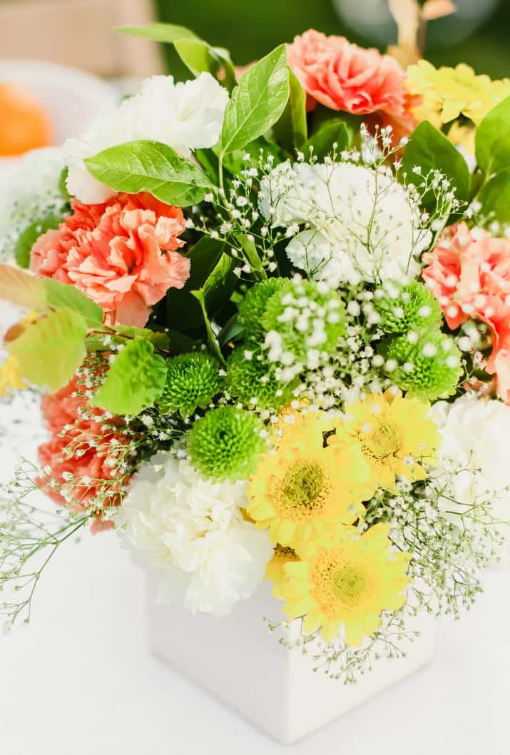 summer flower centerpiece in orange, yellow, and white