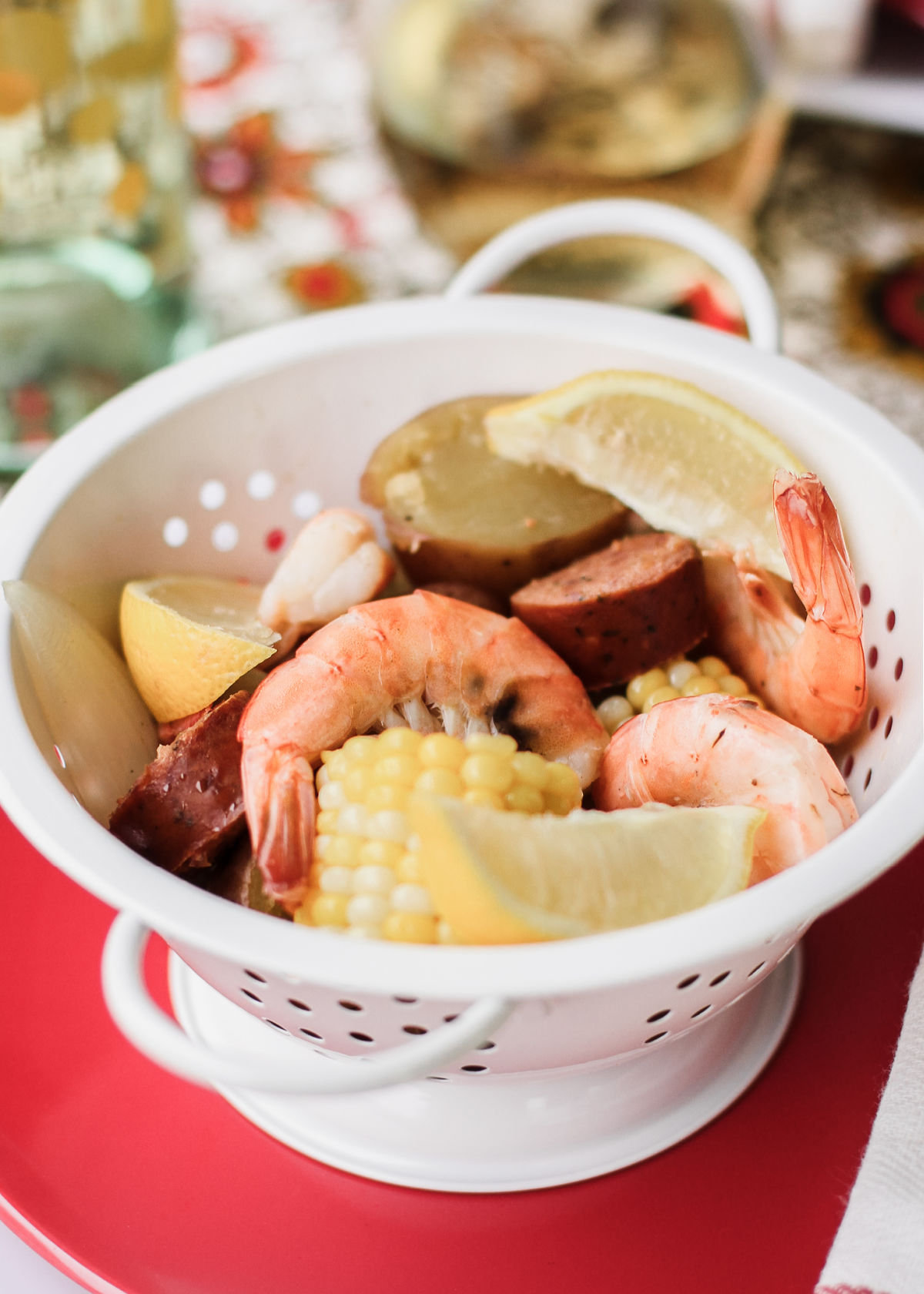 shrimp, sausage, potatoes and corn in white colander.