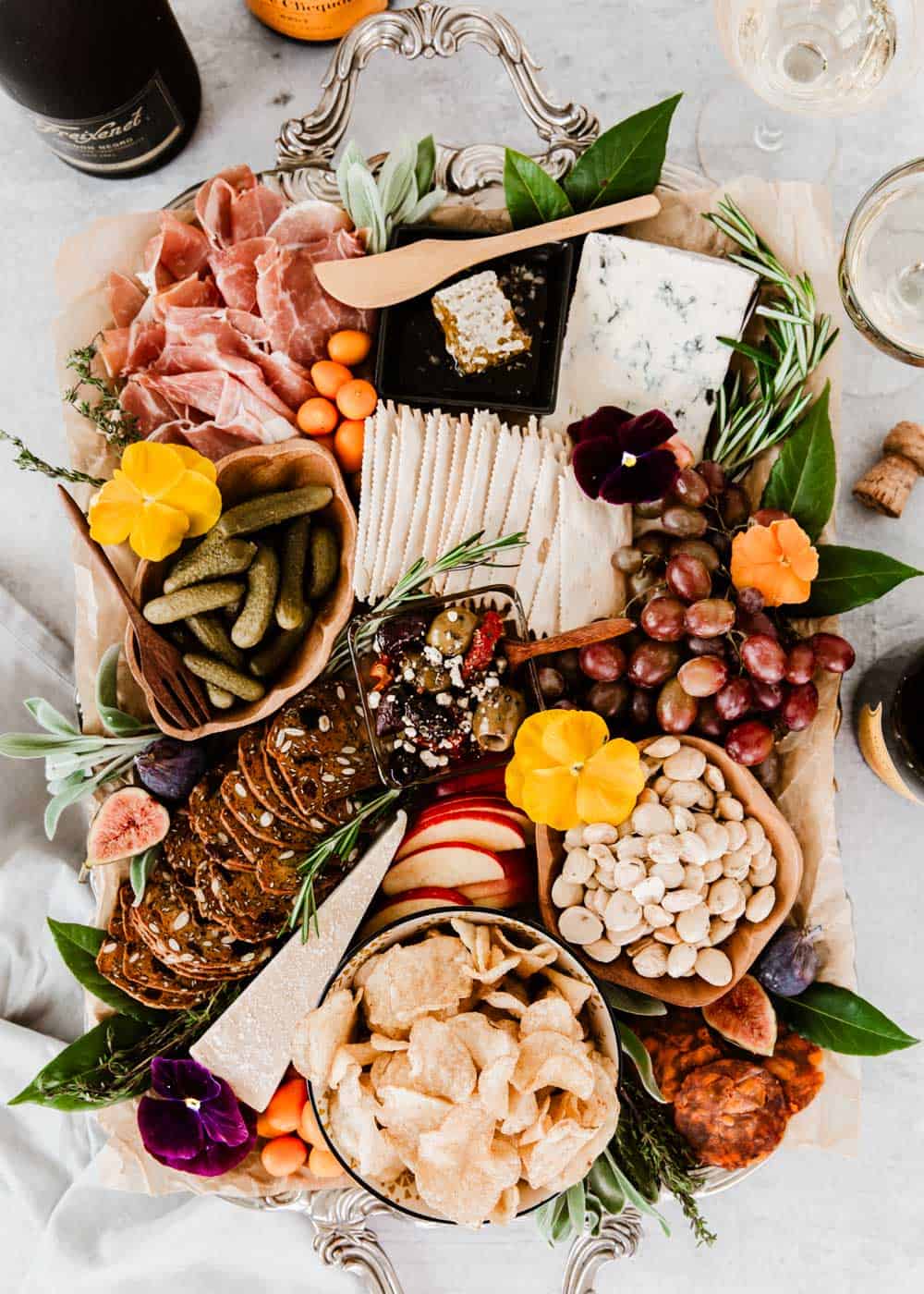 charcuterie board filled with cheeses, meats, chips, crackers, nuts, and fruit.