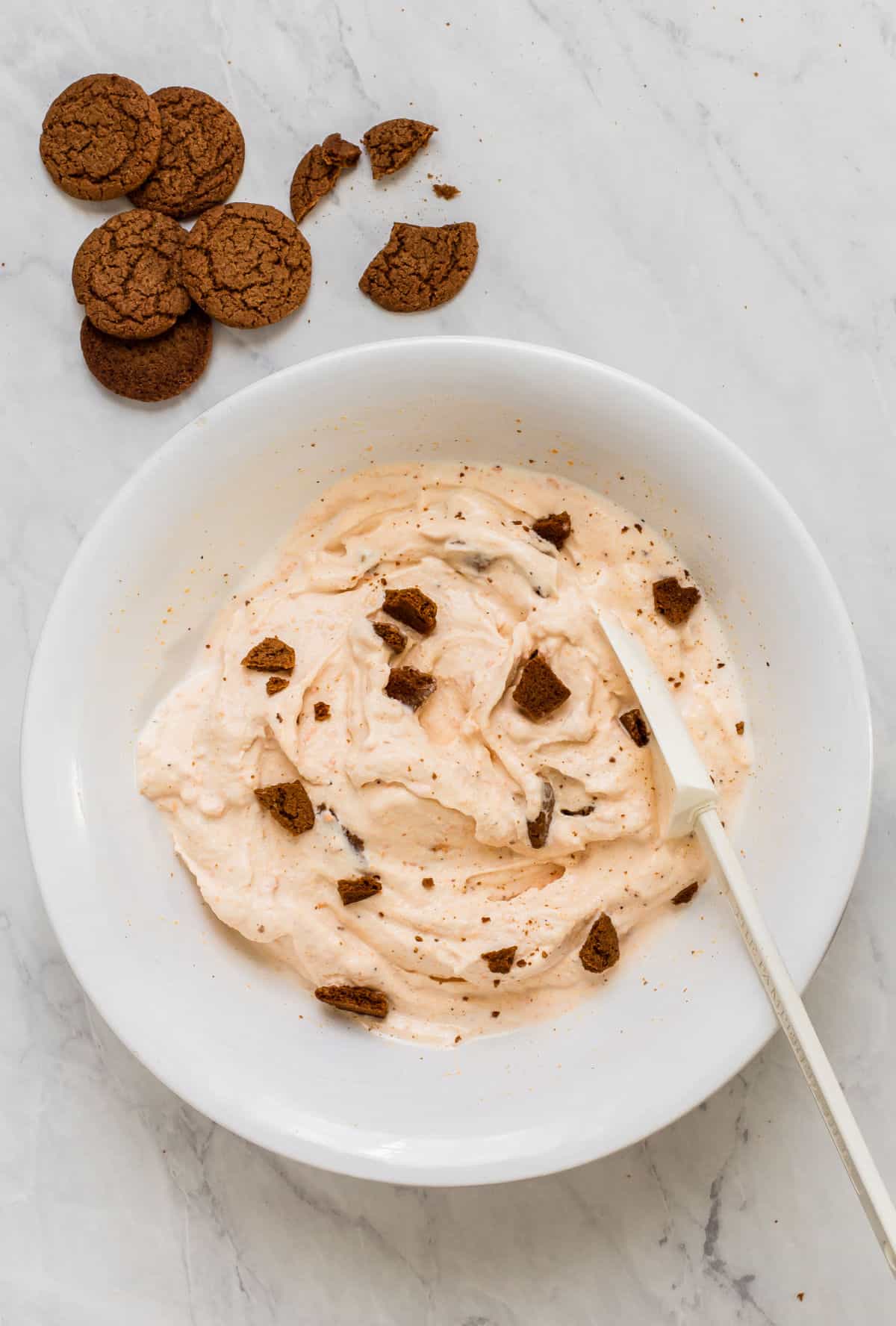 cookies stirred into ice cream in white bowl
