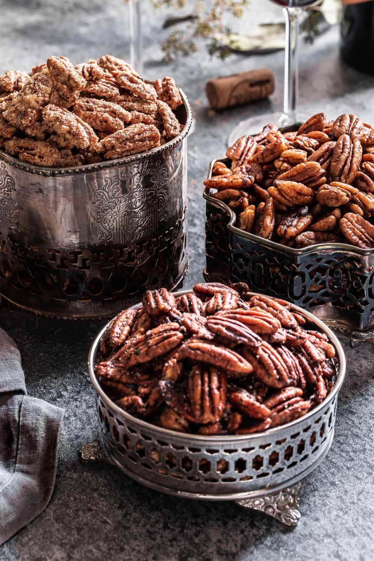 three silver dishes with flavored pecans inside