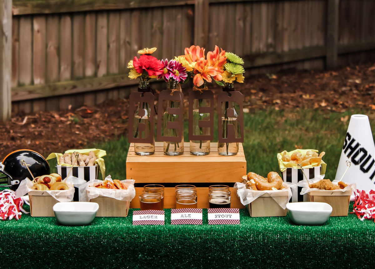 beer table with football theme decor and turf grass table cover.